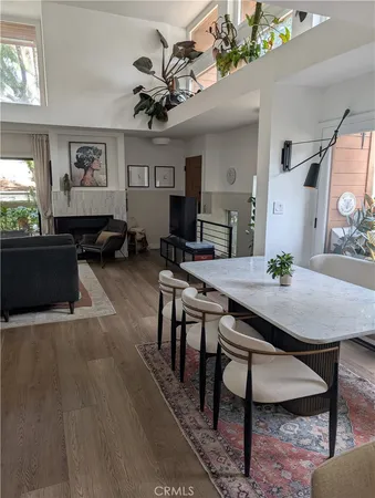 a view of a livingroom and dining room with furniture wooden floor a rug and a chandelier