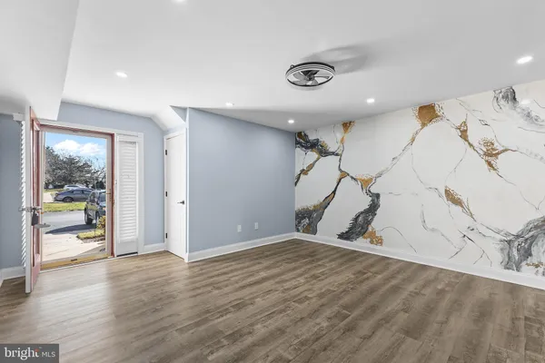 an empty room with wooden floor and natural light