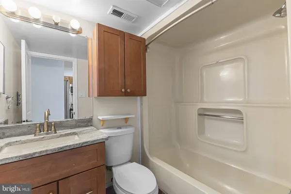a bathroom with a granite countertop sink toilet and shower