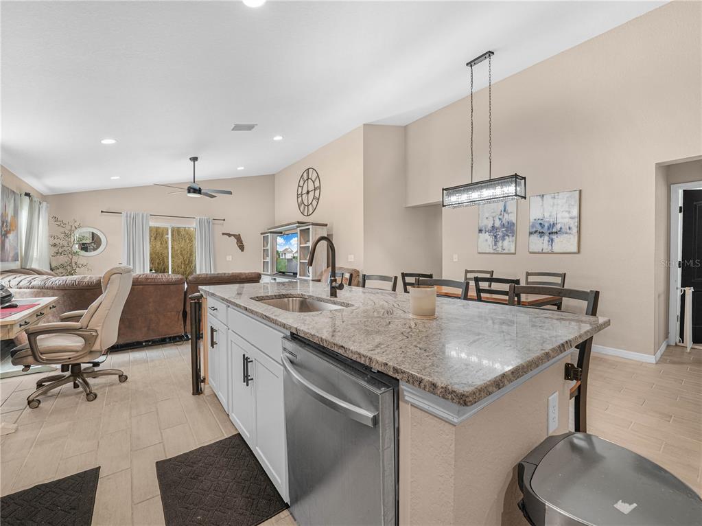 266 South Lake Avenue Frostproof, FL 33843 - Photo 12 of 42 a kitchen with stainless steel appliances granite countertop a sink a stove and a wooden floors