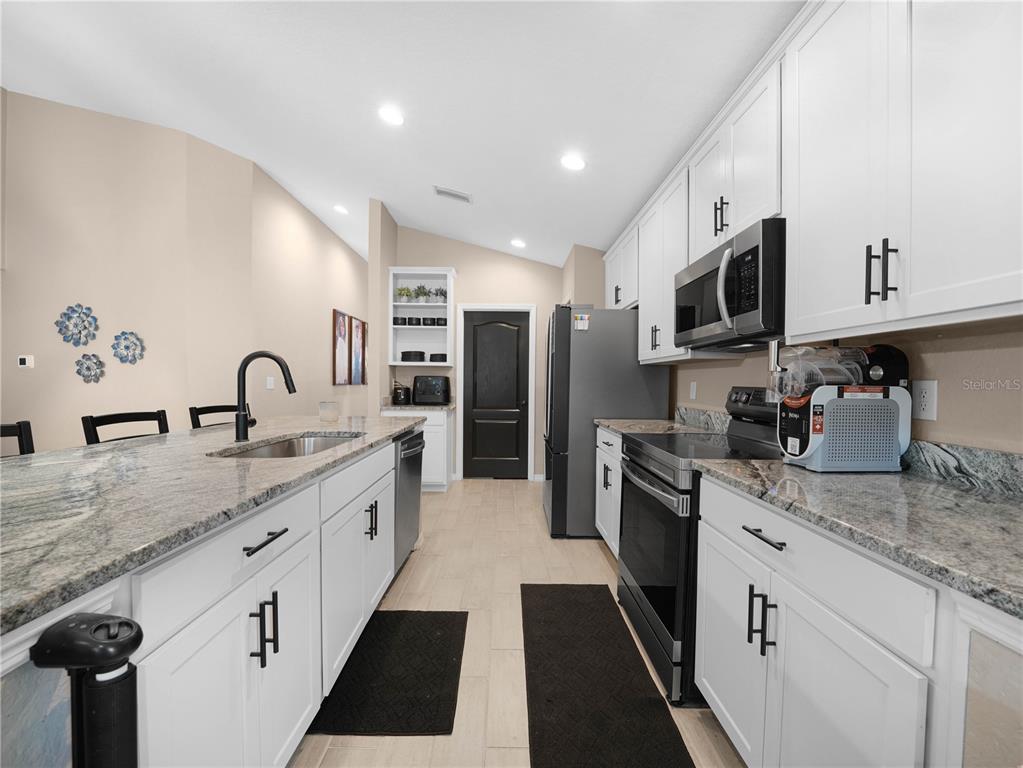 266 South Lake Avenue Frostproof, FL 33843 - Photo 13 of 42 a kitchen with granite countertop a sink stainless steel appliances and cabinets