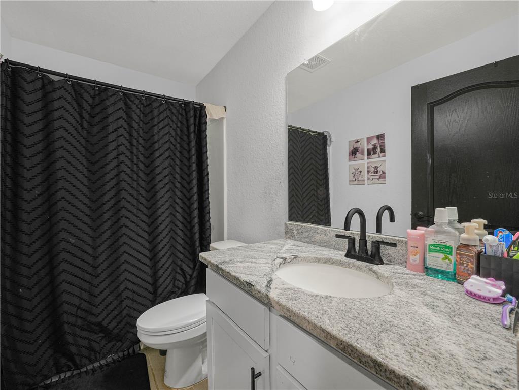 266 South Lake Avenue Frostproof, FL 33843 - Photo 18 of 42 a bathroom with a granite countertop sink toilet and mirror