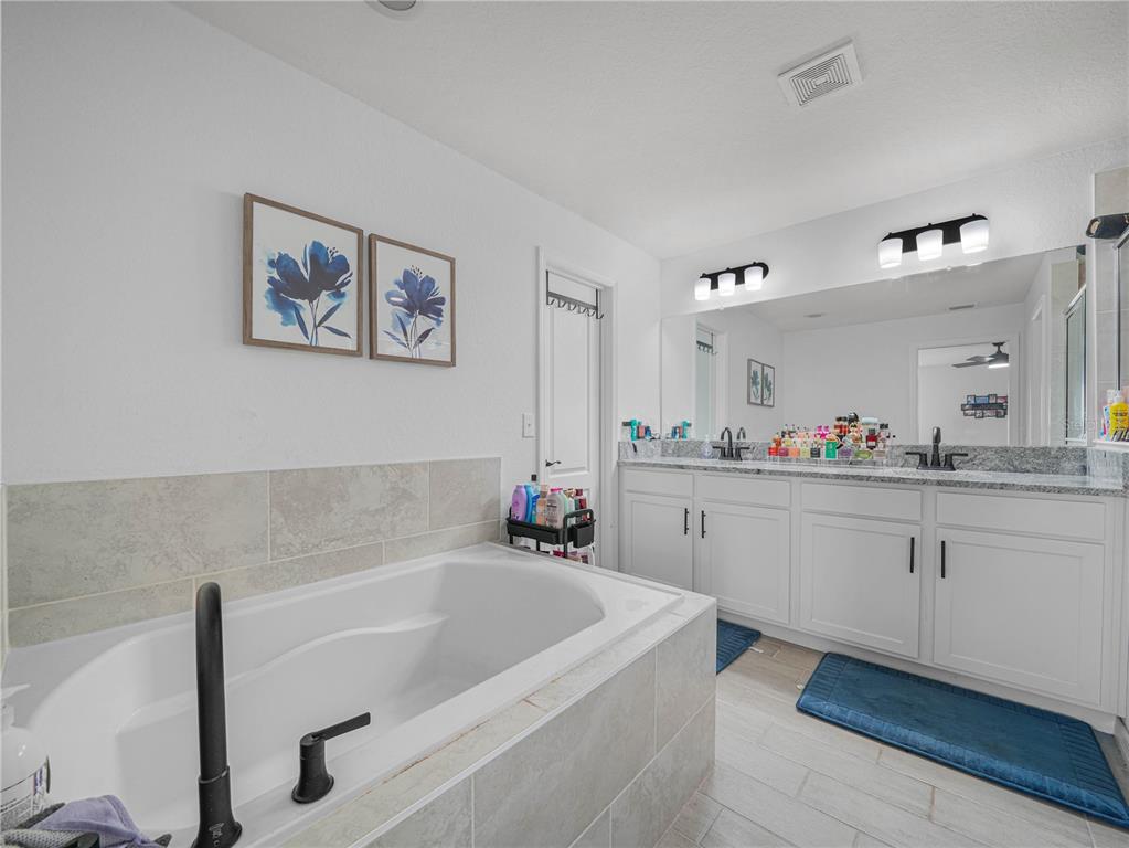 266 South Lake Avenue Frostproof, FL 33843 - Photo 28 of 42 a spacious bathroom with a tub sink and mirror
