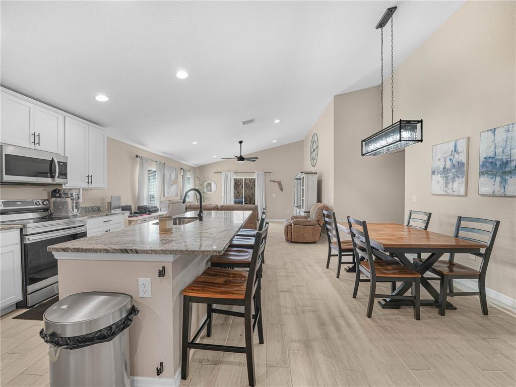 266 South Lake Avenue Frostproof, FL 33843 - Photo 8 of 42 a kitchen with a dining table chairs and white cabinets