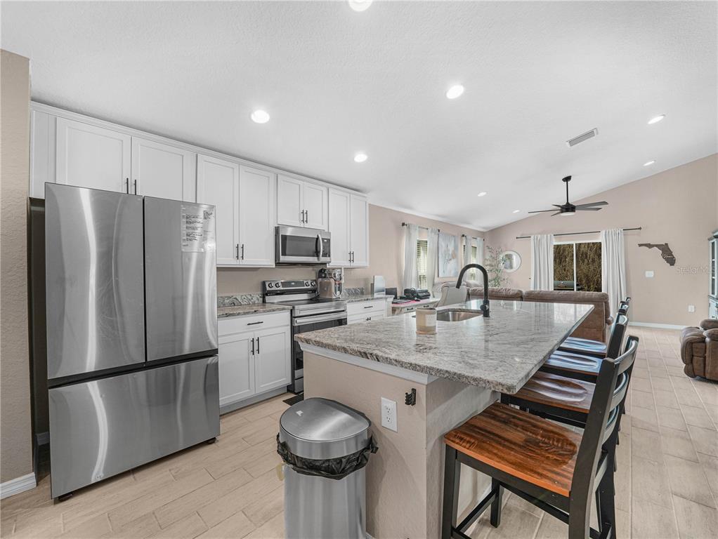 266 South Lake Avenue Frostproof, FL 33843 - Photo 9 of 42 a kitchen with refrigerator and chairs