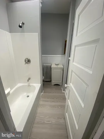 a bathroom with a tub a sink and a large mirror
