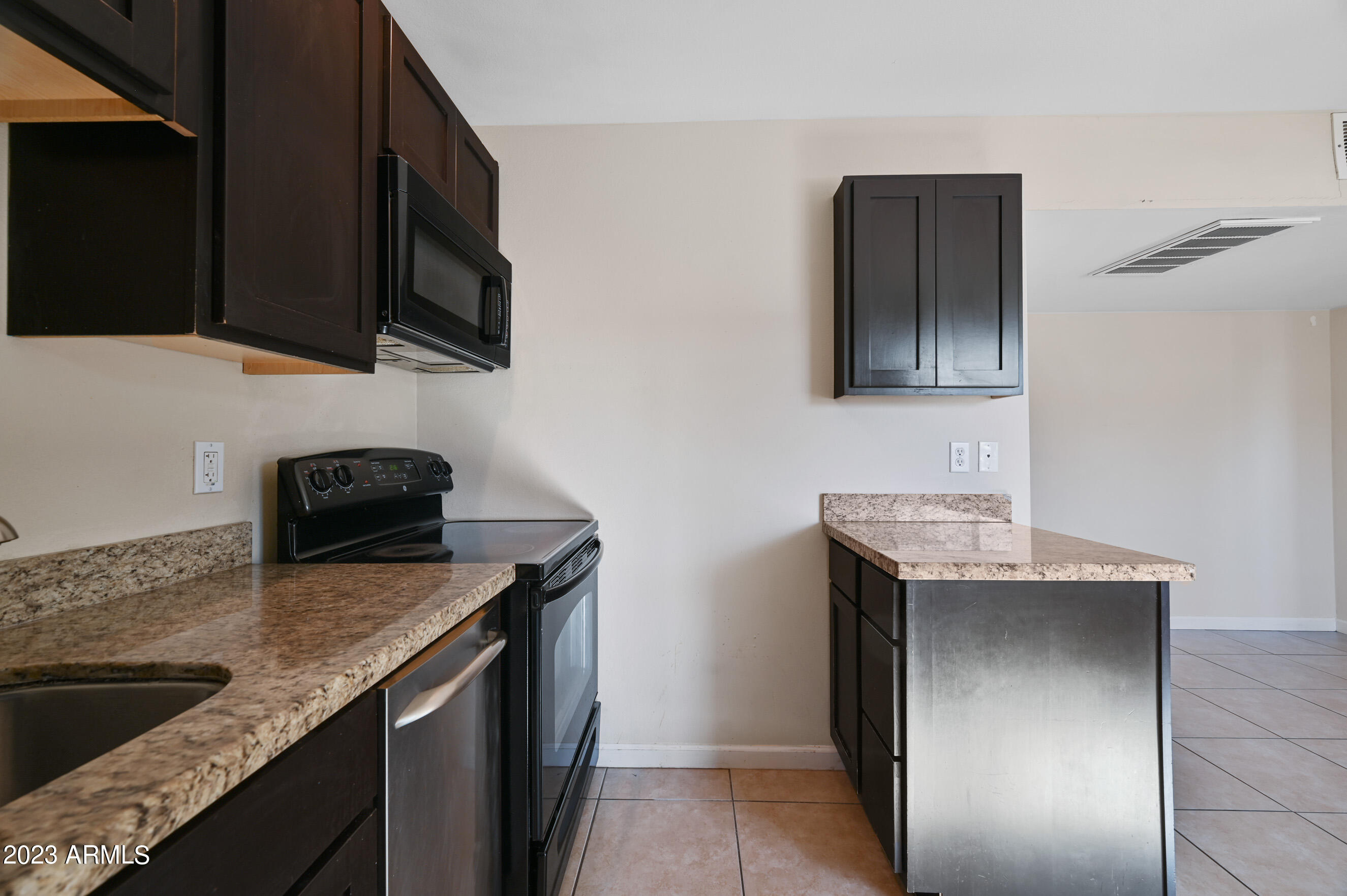 3949 East Earll Drive, Unit 4 Phoenix, AZ 85018 - Photo 7 of 11 a kitchen with stainless steel appliances granite countertop a sink stove and microwave