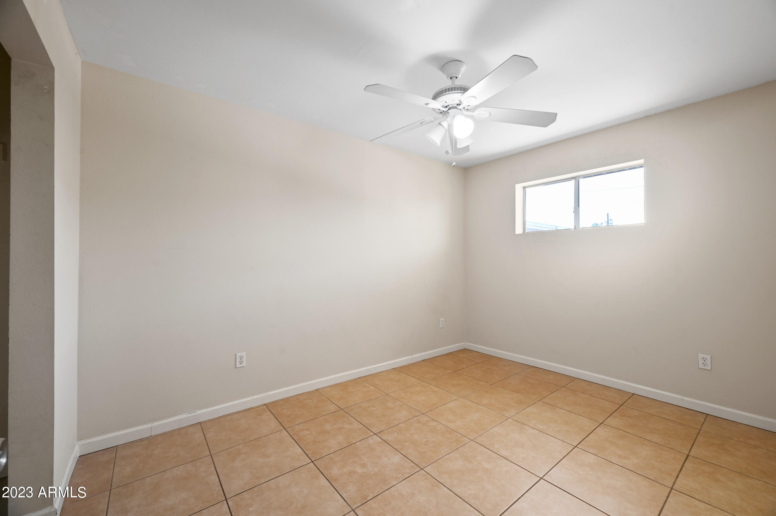 3949 East Earll Drive, Unit 4 Phoenix, AZ 85018 - Photo 9 of 11 an empty room with a window and chandelier fan