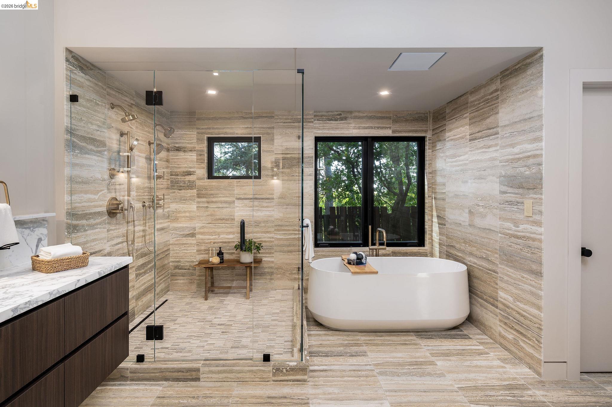 5645 Bacon Road Oakland, CA 94619 - Photo 70 of 94 Spacious bathroom featuring a frameless glass shower enclosure, a freestanding soaking tub, and a floating vanity with a light-toned countertop