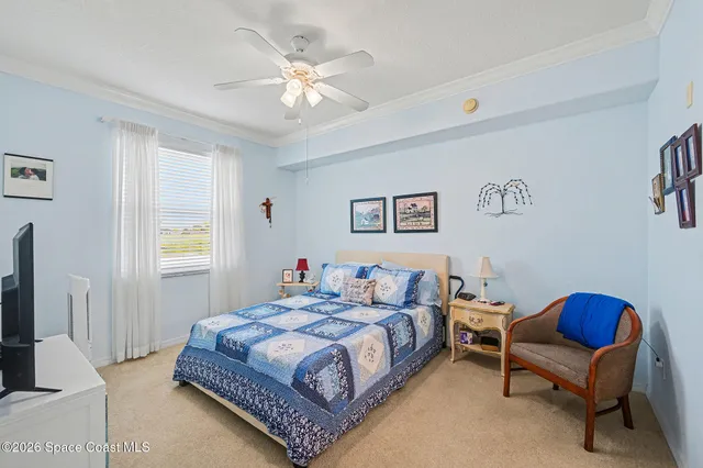 a bedroom with a bed a chair and a flat screen television