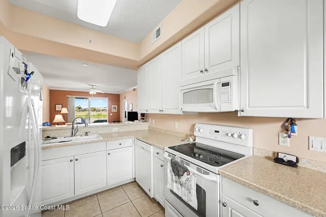 a kitchen with white cabinets sink and white appliances
