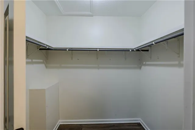 an empty room with wooden floor ceiling fan and windows