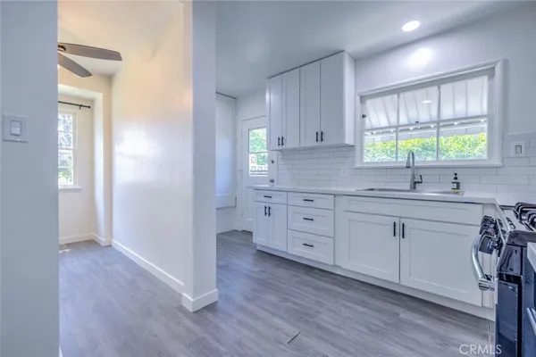 a kitchen with white cabinets sink and window