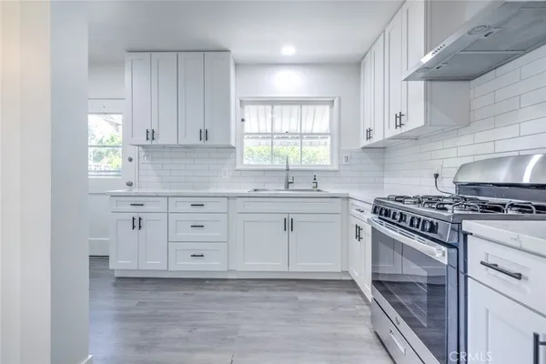 a kitchen with granite countertop white cabinets and appliances