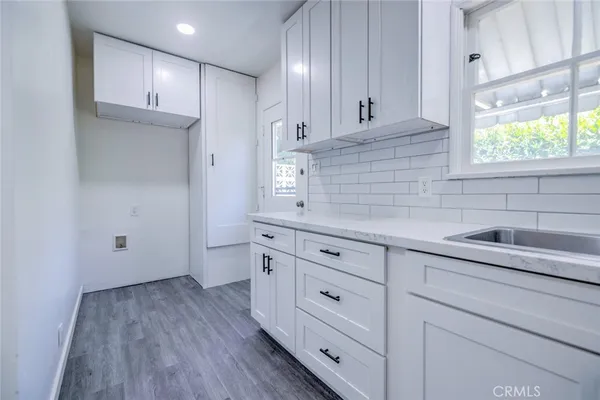 a kitchen with granite countertop white cabinets and white appliances