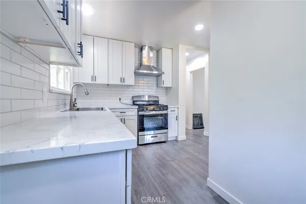 a kitchen with a sink cabinets and wooden floor