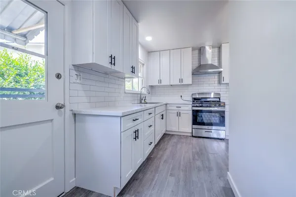 a kitchen with stainless steel appliances a white stove top oven and sink