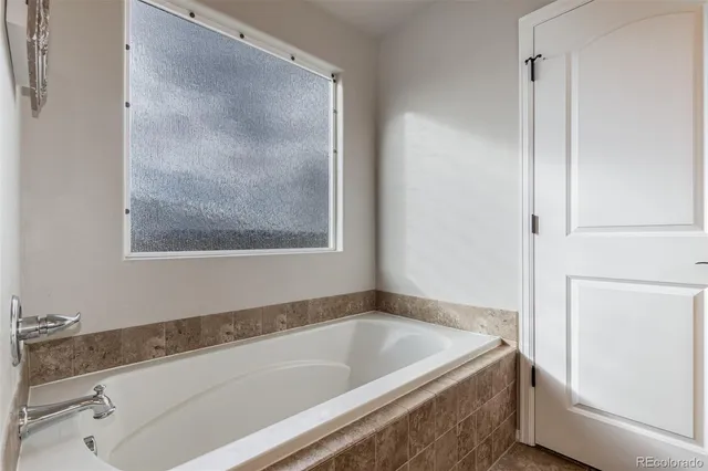 a bath tub sitting next to a white sink and vanity