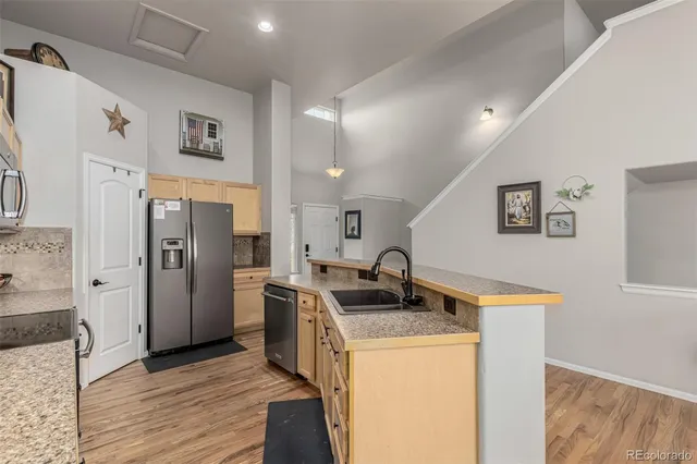 a kitchen that has a sink a refrigerator and a stove top oven