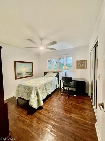 a bed sitting in a spacious bedroom next to a window