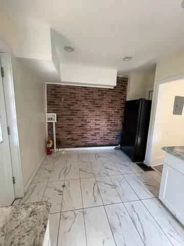 a kitchen with granite countertop a sink a stove and white cabinets