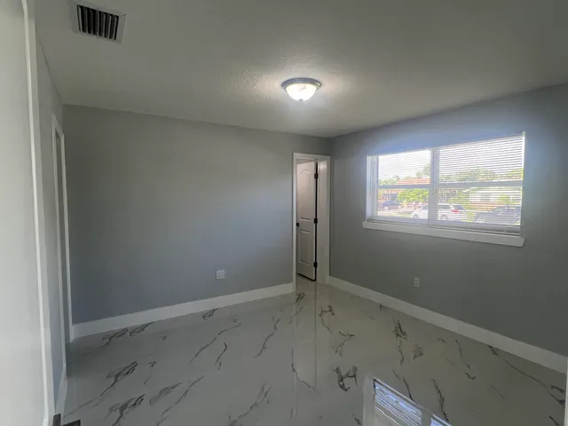 an empty room with closet and windows