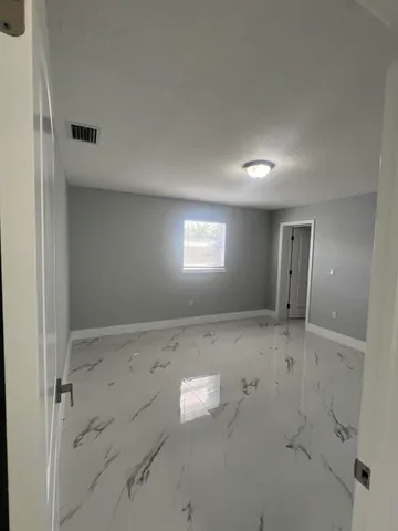 an empty room with windows and closet