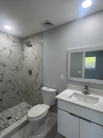 a bathroom with a sink toilet and mirror