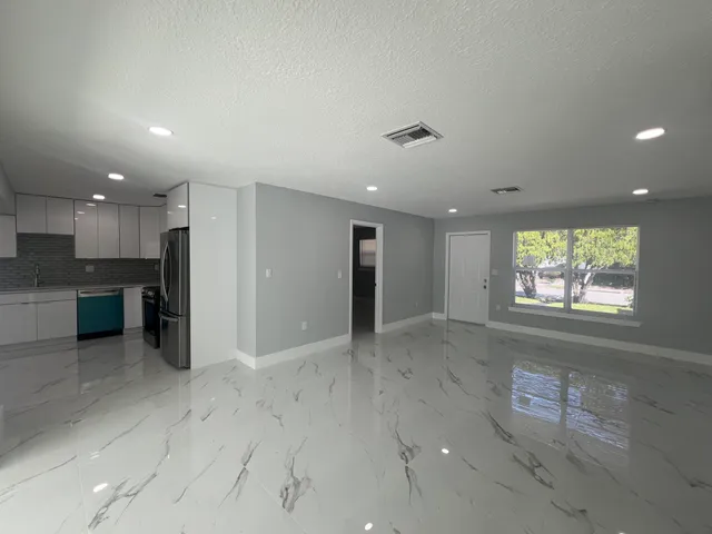 a large kitchen with a refrigerator a stove top oven a sink and dishwasher