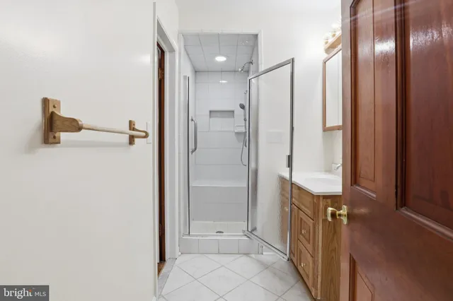 a bathroom with a glass shower door and a mirror