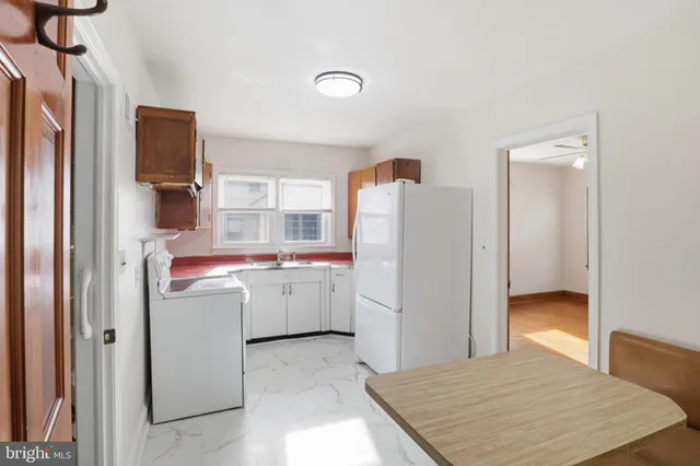 a room with a refrigerator and a dresser