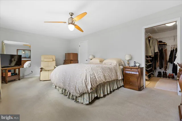a spacious bedroom with a bed and a chandelier