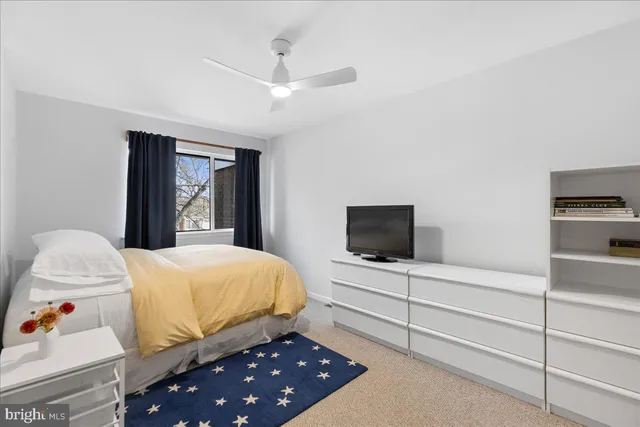 a bedroom with a bed and a flat tv screen on dresser