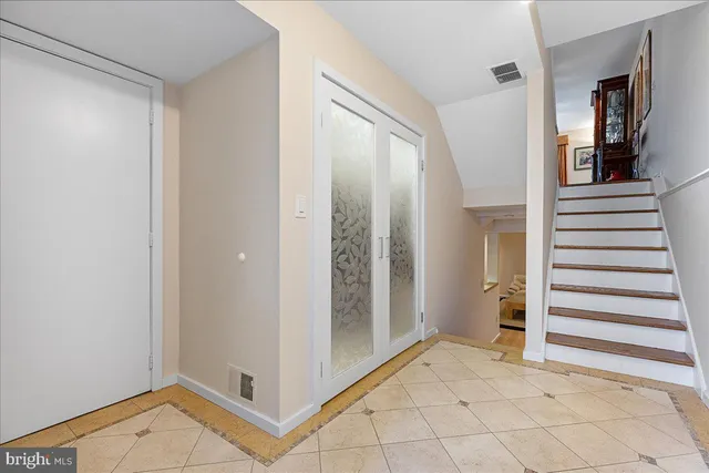 a view of a hallway with entryway and stairs