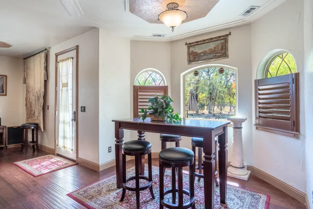 a living room with furniture a dining table and a chandelier