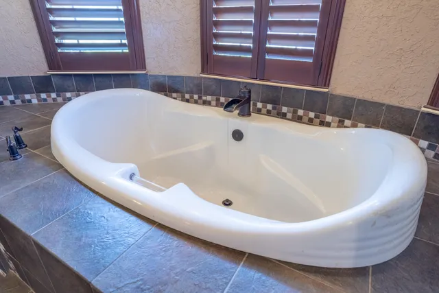 a bathroom with a granite countertop double vanity sink a mirror a vanity and a window