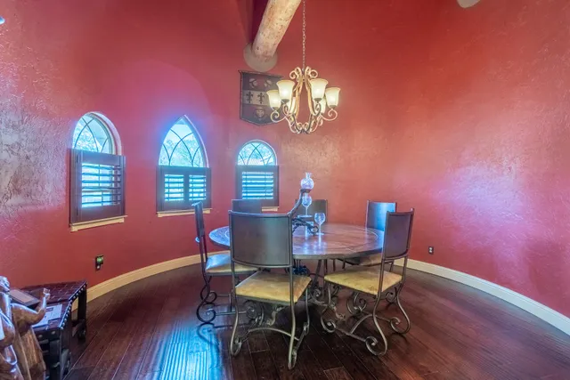 a view of a dining room with furniture a chandelier and wooden floor