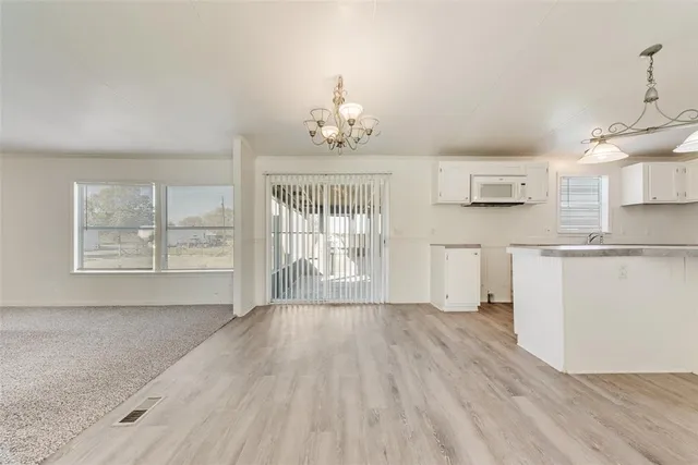 a view of a kitchen with wooden floor and a large window
