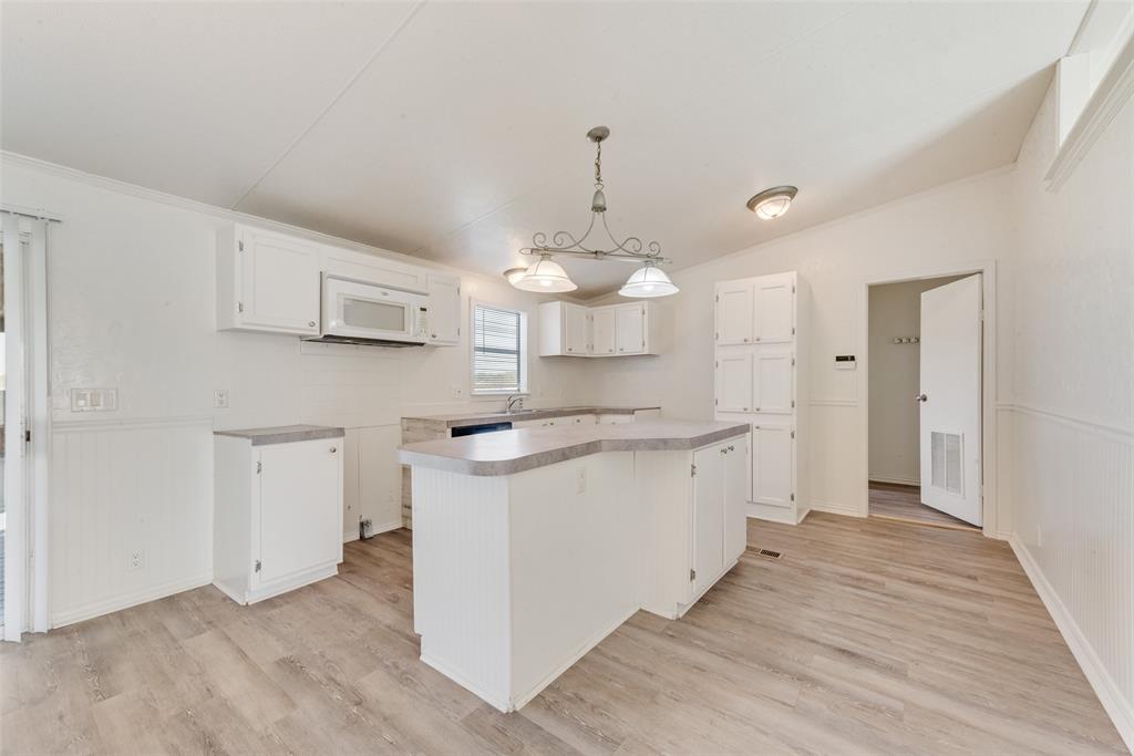 817 Kaufman Street Rosser, TX 75158 - Photo 11 of 29 a kitchen with kitchen island white cabinets and white appliances
