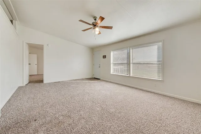 a view of a livingroom with a ceiling fan and window