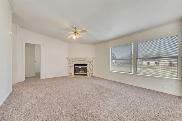 a view of empty room with a fireplace and fan