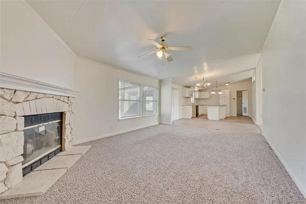 a view of a big room with wooden floor and kitchen