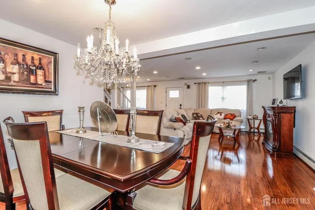 a very nice looking dining room with furniture a chandelier and wooden floor