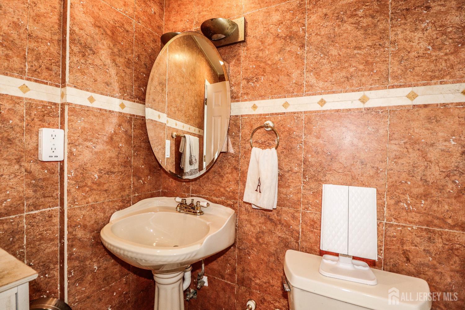 76 Daniel Street Carteret, NJ 07008 - Photo 20 of 37 a bathroom with a sink a toilet and mirror