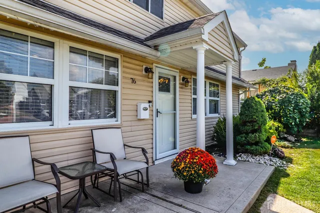 a front view of a house with a yard balcony and seating space