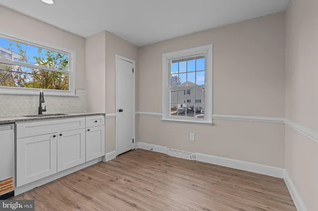 a view of a kitchen with wooden floor cabinets and windows