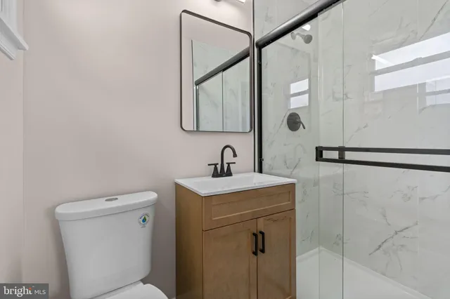 a bathroom with a toilet sink and mirror