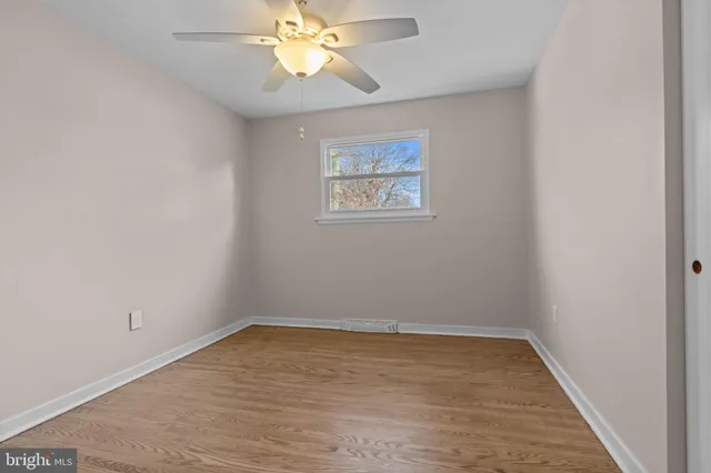 an empty room with a window and wooden floor
