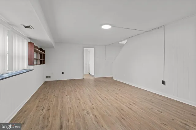 a view of a room with wooden floor and white walls