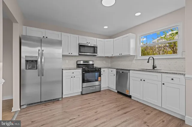 a kitchen with white cabinets and stainless steel appliances